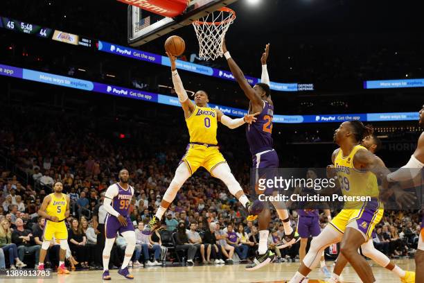 Russell Westbrook of the Los Angeles Lakers lays up a shot past Deandre Ayton of the Phoenix Suns during the first half of the NBA game at Footprint...