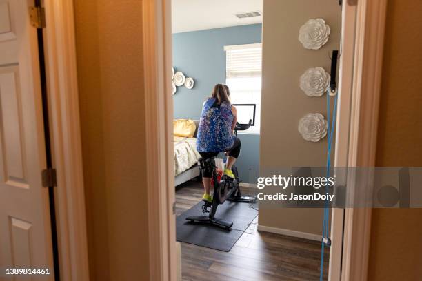 woman riding exercise bicycle - peloton stock pictures, royalty-free photos & images