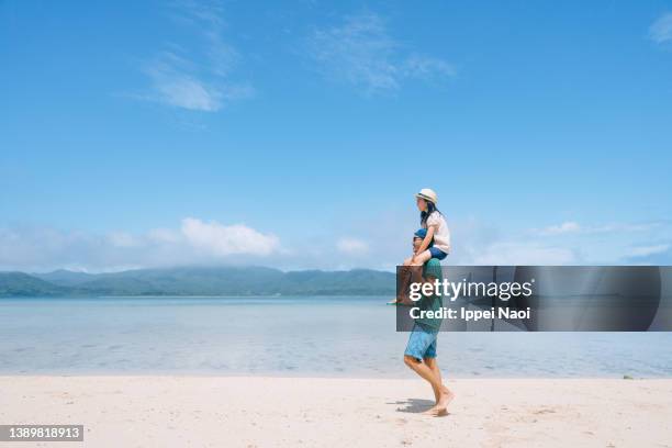 father carrying young daughter on shoulders on beach, japan - carrying a person on shoulders stock pictures, royalty-free photos & images