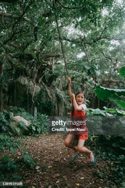 young girl playing tarzan in forest - tarzan stock pictures, royalty-free photos & images