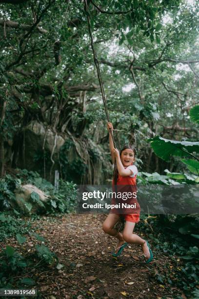 young girl playing tarzan in forest - tarzan imagens e fotografias de stock