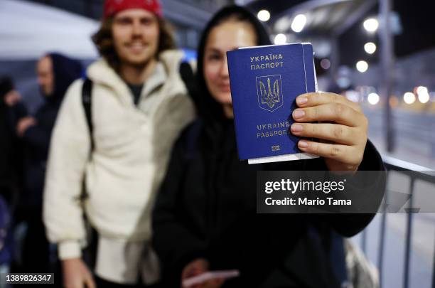 Ukrainian Sasha, who is seeking asylum in the U.S., displays her passport as she waits to cross the U.S.-Mexico border at the San Ysidro Port of...