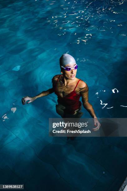 woman standing in the swimming pool - red swimwear stock pictures, royalty-free photos & images