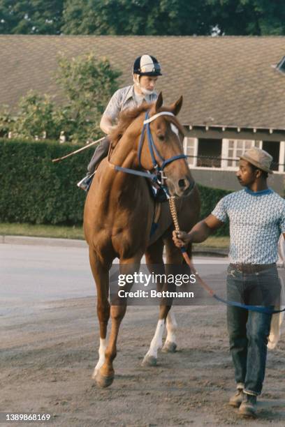 Groom leads American thoroughbred Secretariat and Canadian jockey Ron Turcotte ahead of a workout at Belmont Park in Elmont, New York, 6th June 1973....