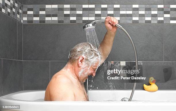 active senior washing in bath - washing hair stock-fotos und bilder