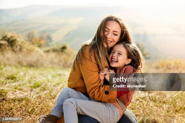 alegre madre soltera e hija divirtiéndose en el día de otoño. - hija fotografías e imágenes de stock