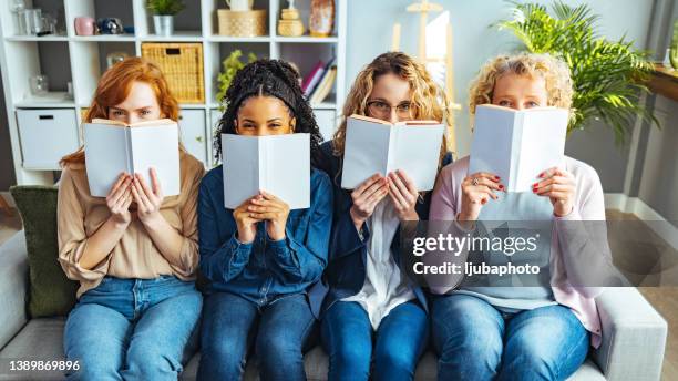 females reading with books obscuring faces - cover book stock pictures, royalty-free photos & images