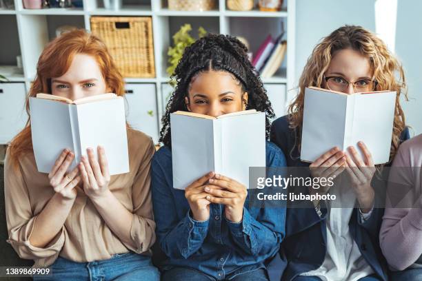 college students hiding behind a books and looking at camera - house oversight committee stock pictures, royalty-free photos & images