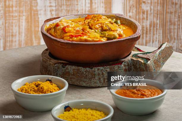 grouper moqueca served with saffron rice, farofa and pirão and pepper sauce. typical brazilian food - southern brazil stock pictures, royalty-free photos & images