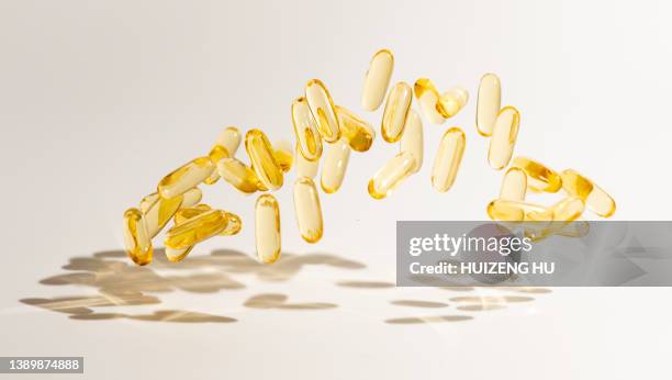 omega 3 capsules floating over white background - fish oil stock photos et images de collection