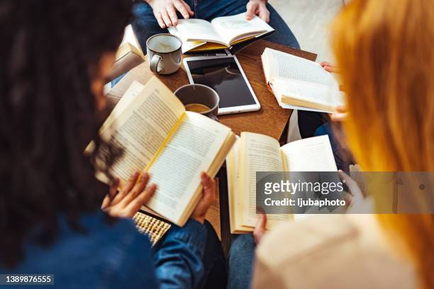 studenti adulti che studiano insieme in biblioteca - libro foto e immagini stock
