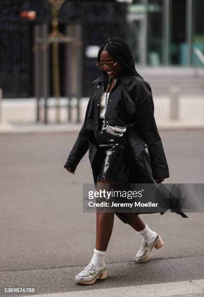 Lois Opoku seen wearing brown sunglasses from Gucci, a black coat from Karl Lagerfeld, a black leather mini skirt from NA-KD, white knit top from...