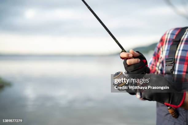 fishing on the lake at sunset. closeup spinning in the male hand, - white perch fish stock pictures, royalty-free photos & images