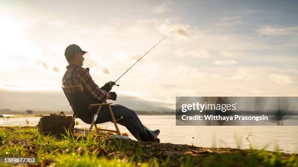 man on a fishing trip by the lake - pescatore foto e immagini stock
