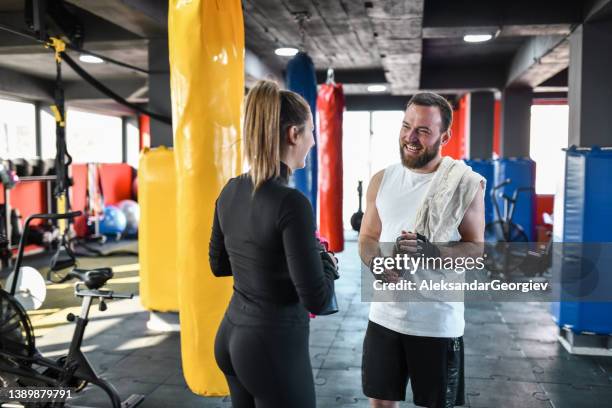 athletic couple enjoying fresh drinks after tough workout in gym - hi five gym stockfoto's en -beelden
