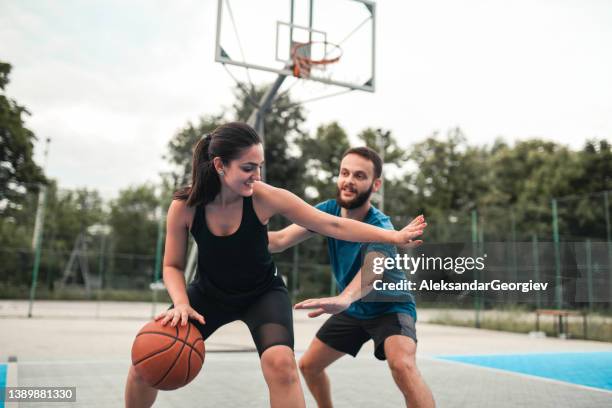 couple enjoying competitive basketball match - young couple at basketball court stock pictures, royalty-free photos & images