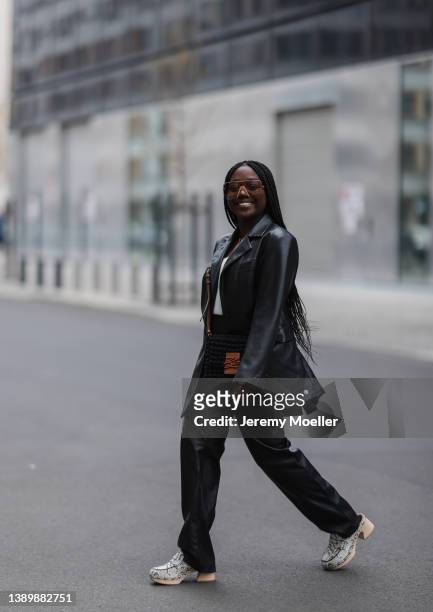 Lois Opoku seen wearing a brown sunglasses from Gucci, a black leather blazer from NA-KD, matching black leather straight leg pants, a white top from...