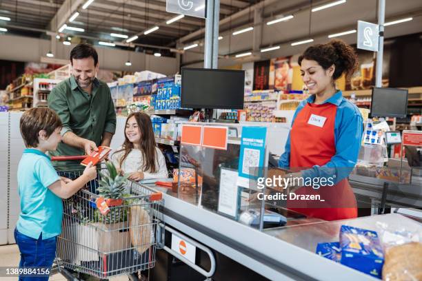família comprando em supermercado, pai pagando no caixa - balcão de pagamento - fotografias e filmes do acervo