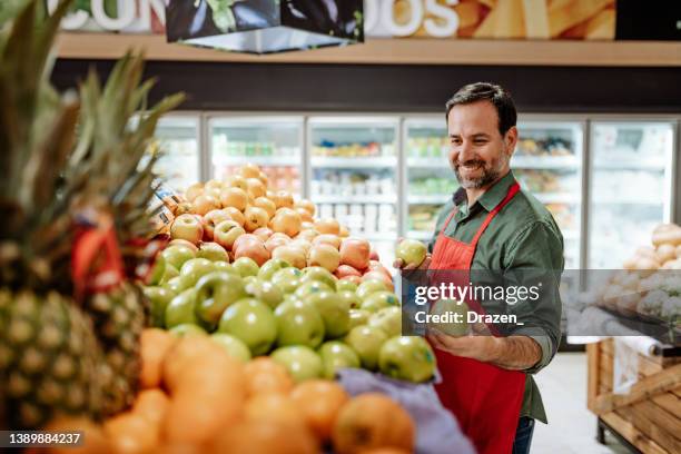 empleado latinoamericano - verdulero en supermercado - friendly salesman fotografías e imágenes de stock
