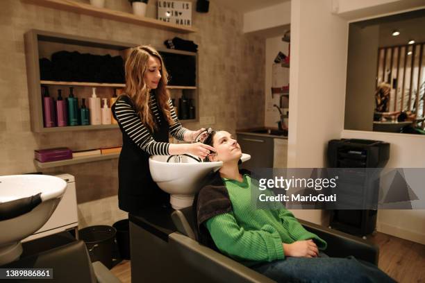 hairdresser washing a customer's hair - hairdresser washing hair stock pictures, royalty-free photos & images