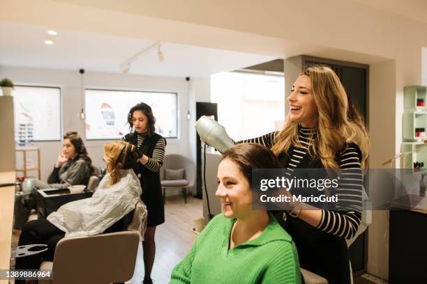 hair stylist using a hair dryer - mid aged stock pictures, royalty-free photos & images