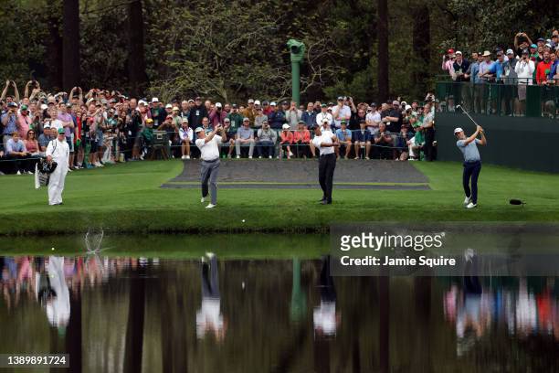Fred Couples of the United States, Tiger Woods of the United States and Justin Thomas of the United States skip balls across the lake on the 16th...
