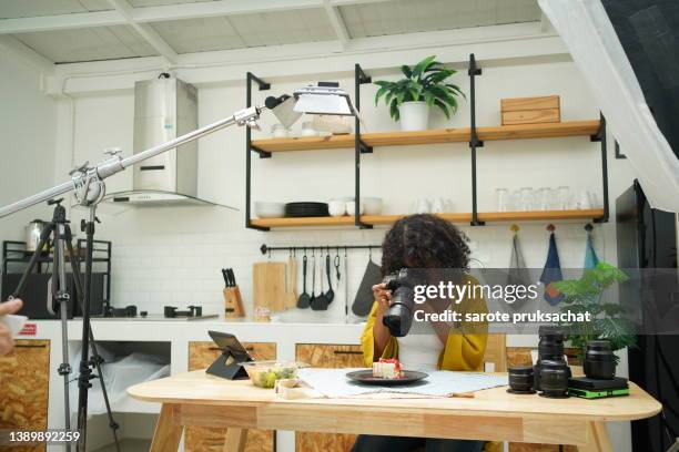 side view of female freelancer photographer checking photos on a digital camera . - digital camera stock pictures, royalty-free photos & images