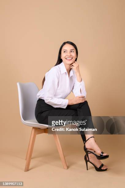 business woman posing in studio - sitzen stock-fotos und bilder