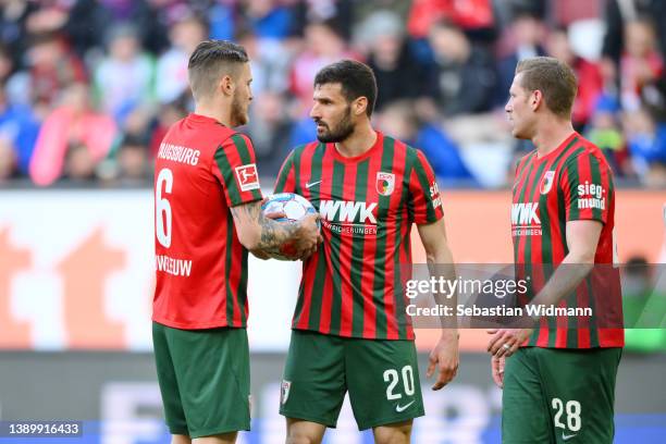 Jeffrey Gouweleeuw of FC Augsburg takes the ball from Daniel Caligiuri of FC Augsburg to take a penalty sh during the Bundesliga match between FC...