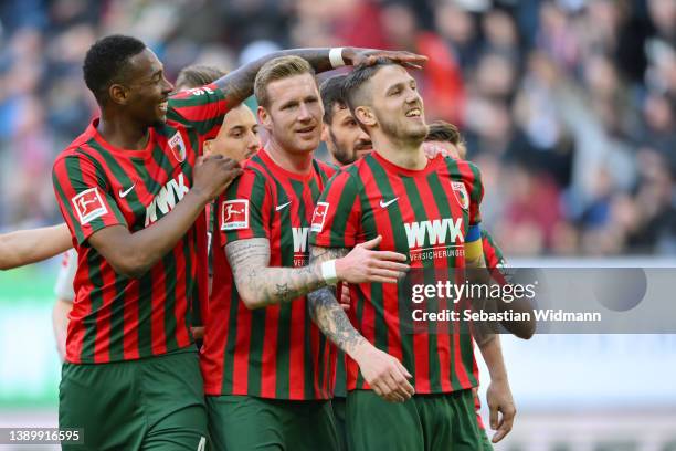 Jeffrey Gouweleeuw of FC Augsburg celebrates with teammates after scoring their team's first goal from the penalty spot during the Bundesliga match...