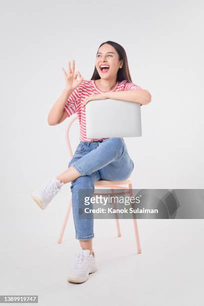 successful young businesswoman sitting on chair with laptop - woman excited sitting chair stock pictures, royalty-free photos & images