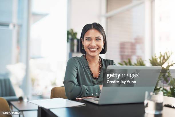 shot of a young businesswoman using a laptop in a modern office - sitting at a laptop with facebook stock pictures, royalty-free photos & images