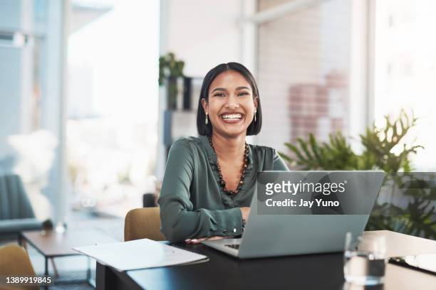 scatto di una giovane imprenditrice che usa un laptop in un ufficio moderno - sedersi posizione fisica foto e immagini stock
