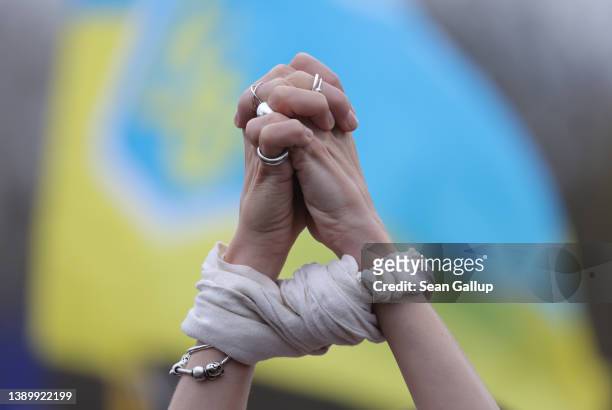 Protester holds up her hands symbolically bound in reference to the bound and murdered civilians of the Ukrainian town of Bucha near Kyiv during a...