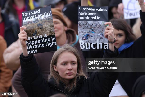 Protester holds up photographs showing murdered civilians of the Ukrainian town of Bucha near Kyiv during a demonstration against the Russian...