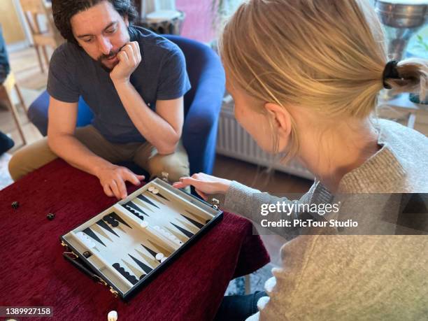 young couple playing backgammon at home - backgammon 個照片及圖片檔