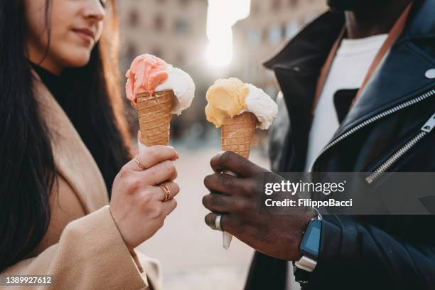 primer plano de dos personas sosteniendo helados al atardecer - gelato fotografías e imágenes de stock