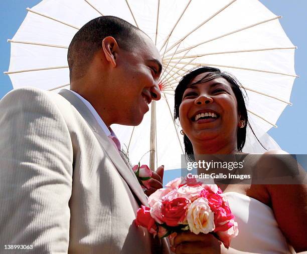 Sumaiyau Freeman and Brett Syster, one of the ten couples who tied the knot during the 12th annual mass Valentine's Day wedding ceremony, smile at...