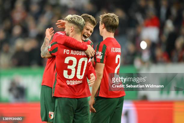 Niklas Dorsch, Florian Niederlechner and Robert Gumny of FC Augsburg celebrate following their side's victory in the Bundesliga match between FC...
