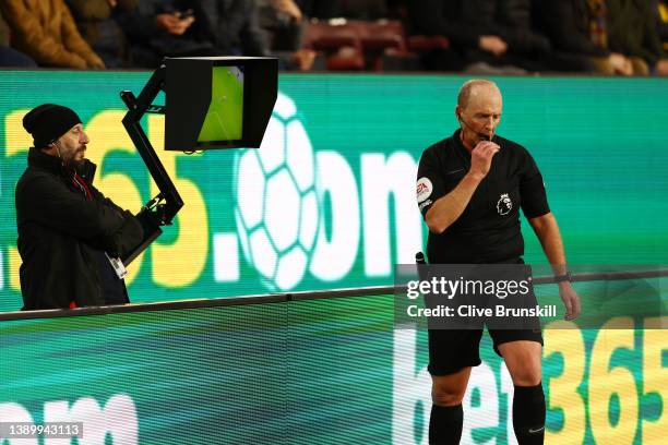 Match referee Mike Dean signals for a penalty following a VAR review during the Premier League match between Burnley and Everton at Turf Moor on...