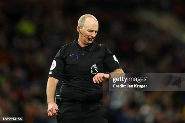 Match referee Mike Dean checks his watch during the Premier League match between Burnley and Everton at Turf Moor on April 06, 2022 in Burnley,...