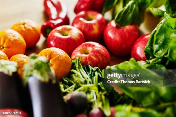 close up shot of fresh organic fruit and vegetables on kitchen counter - vers fruit stockfoto's en -beelden