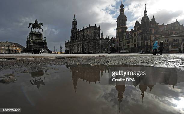 The silhouette of Dresden is reflected in a puddle (L-R: The monument of King John, the Hofkirche and the Castle, on February 15, 2012 in Dresden,...