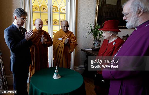 Buddhist guests, Chairman of the Buddhist Society Dr. Desmond Biddulph, Venerable Ajahn Amaro Bhikku, and Venerable Bogoda Seelawimala pray after...