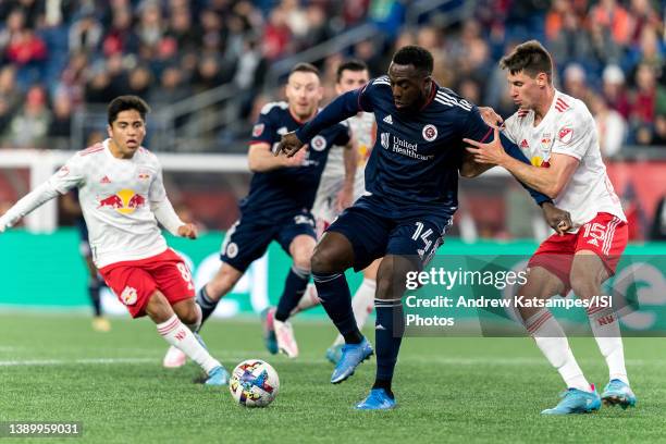 Jozy Altidore of New England Revolution attempts to control the ball as Sean Nealis of New York Red Bulls pressures during a game between New York...