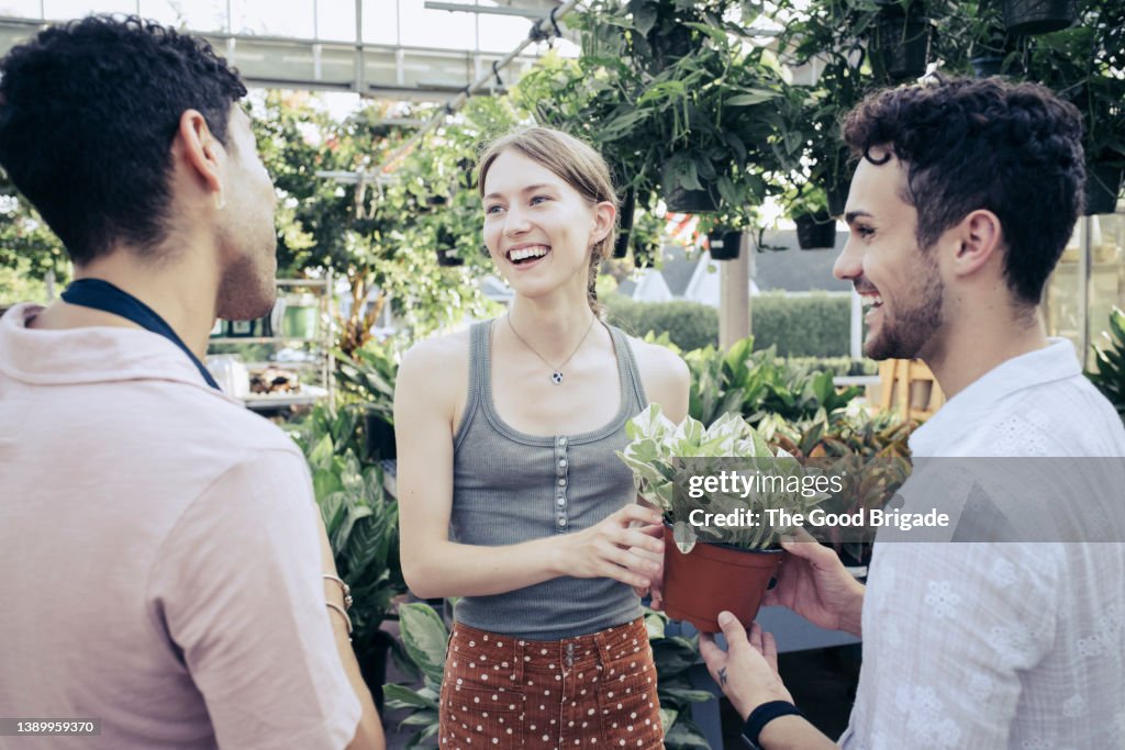 Worker in garden center helping customers