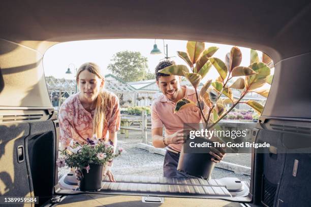 customer loading plants into car trunk at garden center - plant nursery stock pictures, royalty-free photos & images