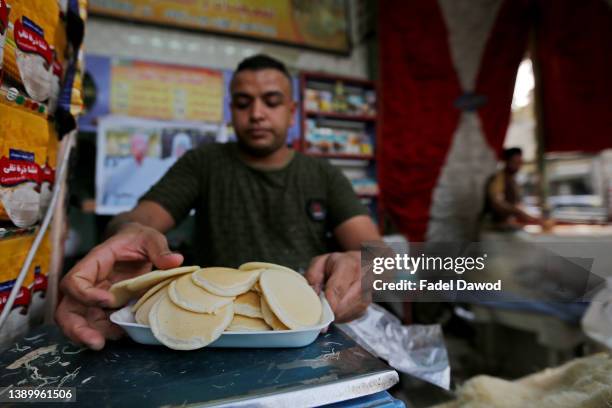 An Egyptian baker prepares Qatayef, a traditional pastry sold during Muslims fasting month of Ramadan, at a market in shubra Misr district on April...