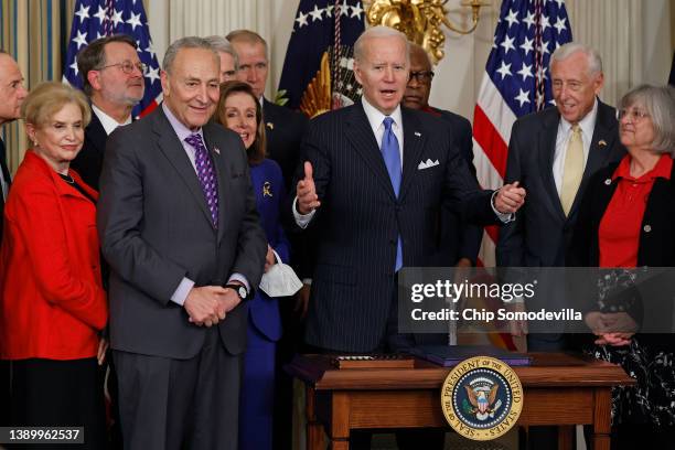 President Joe Biden stands up after signing the Postal Service Reform Act into law during an event with Sen. Tom Carper , Rep. Carolyn Maloney , Sen....