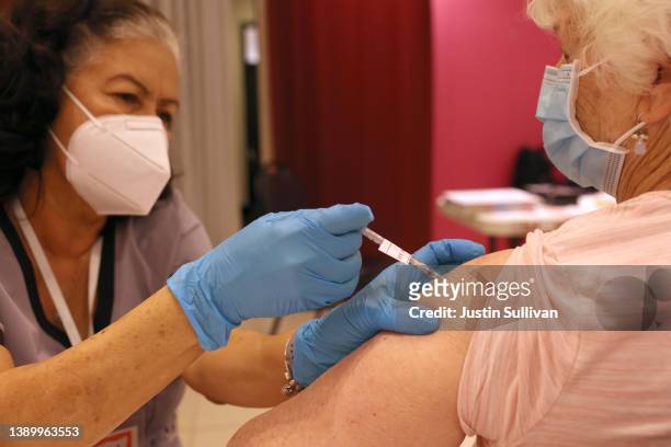 Registered Nurse Orlyn Grace administers a COVID-19 booster vaccination to Jeanie Merriman at a COVID-19 vaccination clinic on April 06, 2022 in San...